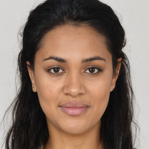 Joyful latino young-adult female with long  brown hair and brown eyes