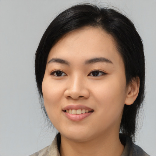Joyful asian young-adult female with medium  black hair and brown eyes