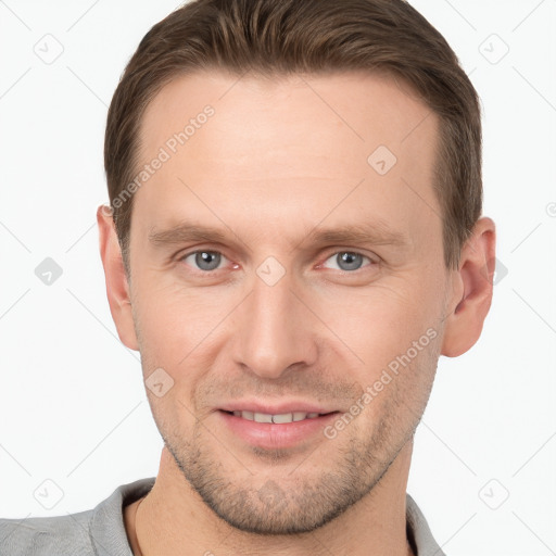 Joyful white young-adult male with short  brown hair and grey eyes