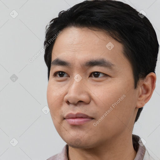 Joyful asian young-adult male with short  black hair and brown eyes