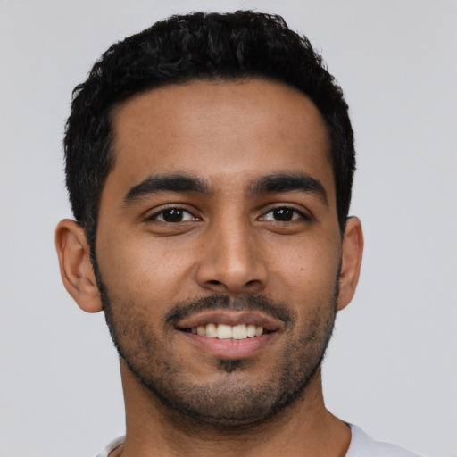 Joyful latino young-adult male with short  black hair and brown eyes