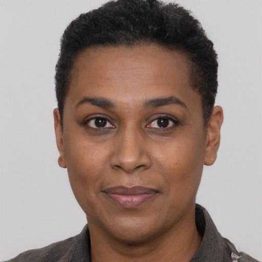 Joyful black adult female with short  black hair and brown eyes