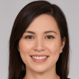 Joyful white young-adult female with long  brown hair and brown eyes