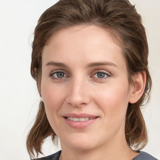 Joyful white young-adult female with medium  brown hair and grey eyes