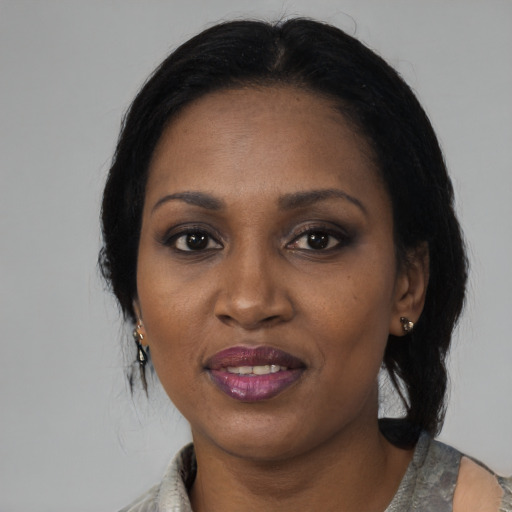 Joyful black adult female with medium  black hair and brown eyes