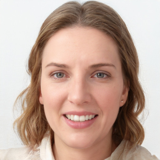 Joyful white young-adult female with medium  brown hair and blue eyes