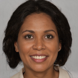 Joyful black adult female with medium  brown hair and brown eyes