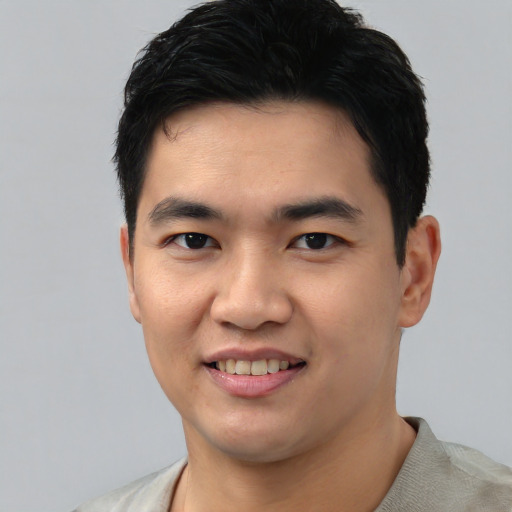 Joyful asian young-adult male with short  black hair and brown eyes