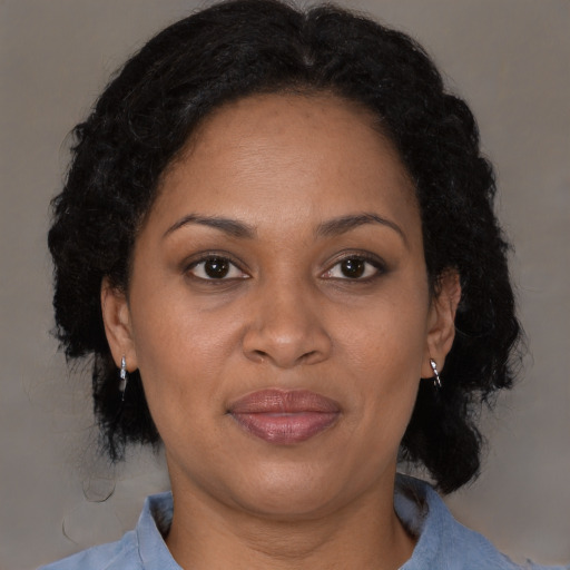 Joyful black adult female with medium  brown hair and brown eyes