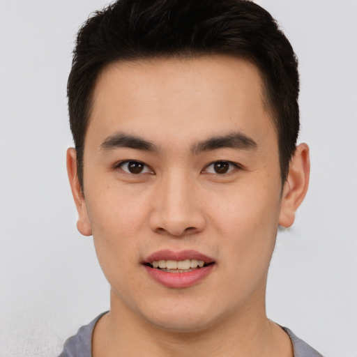 Joyful asian young-adult male with short  brown hair and brown eyes