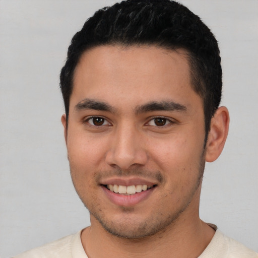 Joyful white young-adult male with short  black hair and brown eyes