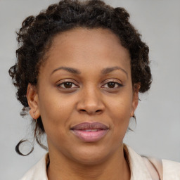 Joyful black adult female with medium  brown hair and brown eyes