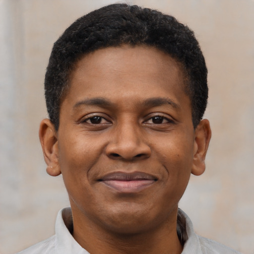 Joyful black young-adult male with short  brown hair and brown eyes