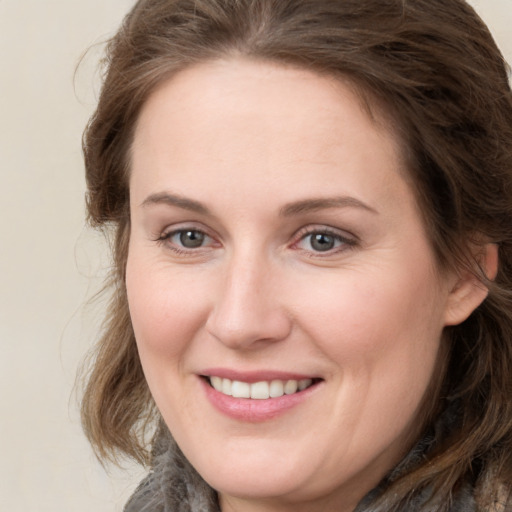 Joyful white young-adult female with medium  brown hair and green eyes