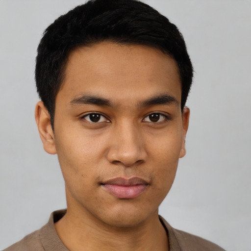 Joyful latino young-adult male with short  black hair and brown eyes