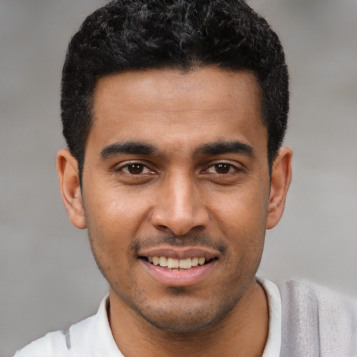 Joyful latino young-adult male with short  black hair and brown eyes