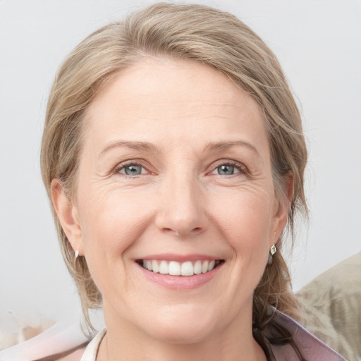 Joyful white adult female with medium  brown hair and grey eyes