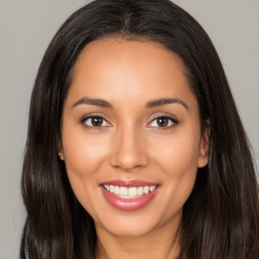 Joyful latino young-adult female with long  brown hair and brown eyes