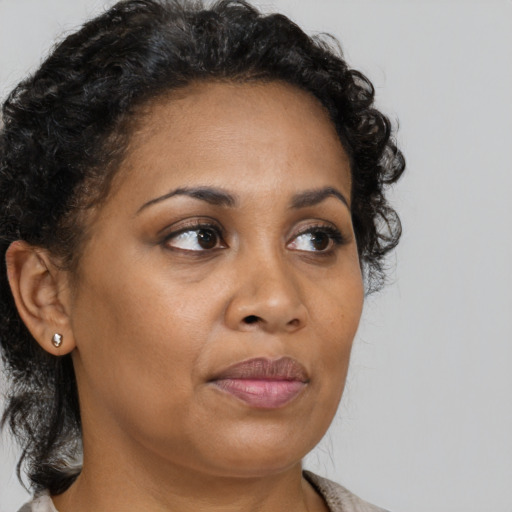 Joyful black adult female with medium  brown hair and brown eyes