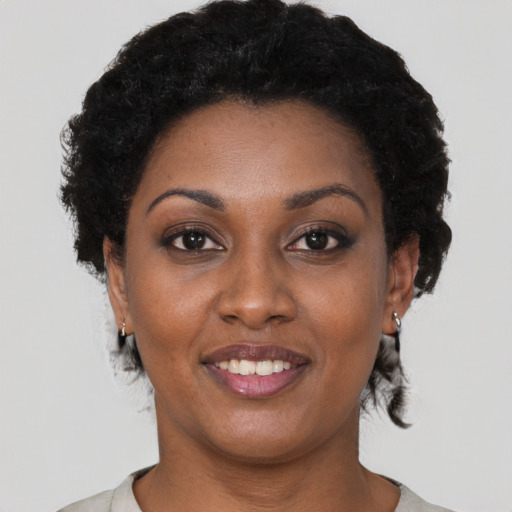 Joyful black young-adult female with short  brown hair and brown eyes