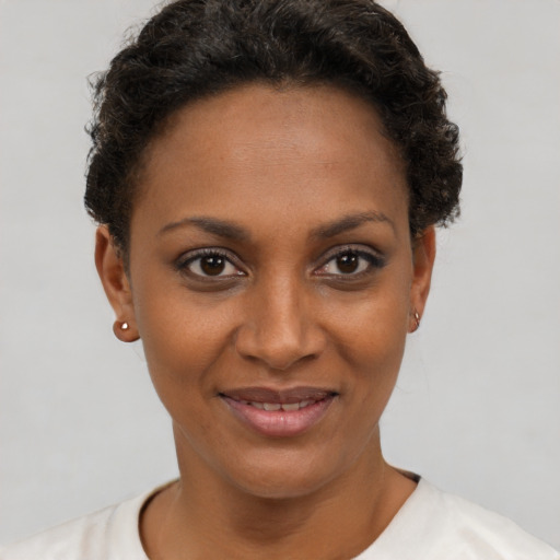 Joyful black young-adult female with short  brown hair and brown eyes