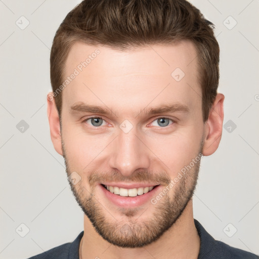 Joyful white young-adult male with short  brown hair and grey eyes