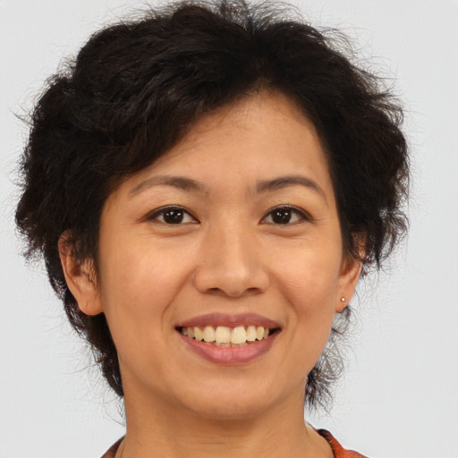 Joyful asian adult female with medium  brown hair and brown eyes