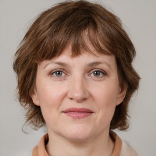 Joyful white adult female with medium  brown hair and grey eyes