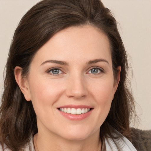 Joyful white young-adult female with medium  brown hair and grey eyes