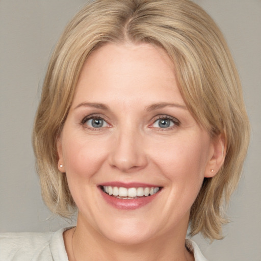 Joyful white adult female with medium  brown hair and blue eyes