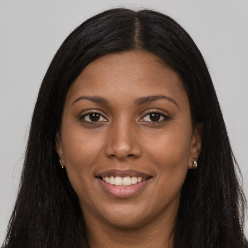 Joyful black young-adult female with long  black hair and brown eyes