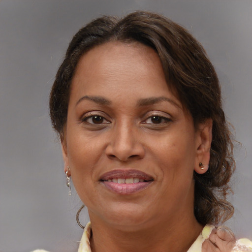 Joyful black adult female with medium  brown hair and brown eyes