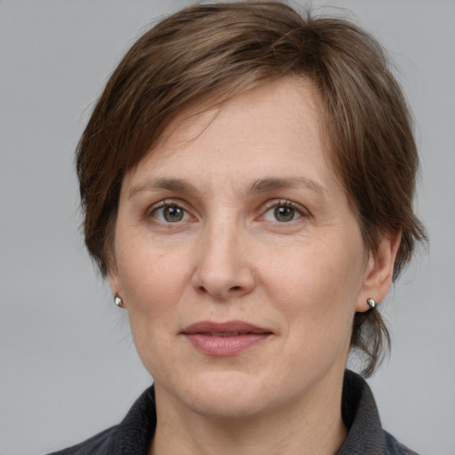 Joyful white adult female with medium  brown hair and grey eyes