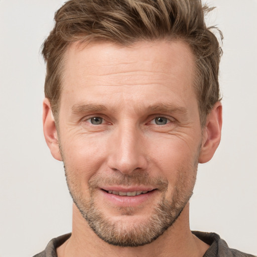 Joyful white adult male with short  brown hair and grey eyes