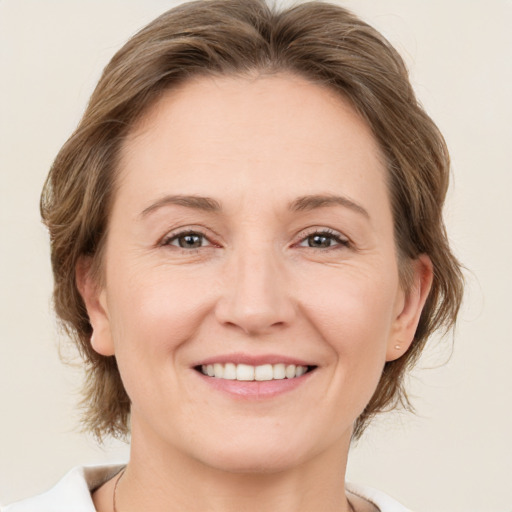 Joyful white adult female with medium  brown hair and brown eyes