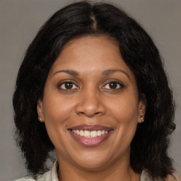 Joyful black adult female with long  brown hair and brown eyes