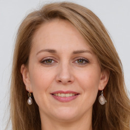 Joyful white adult female with long  brown hair and grey eyes