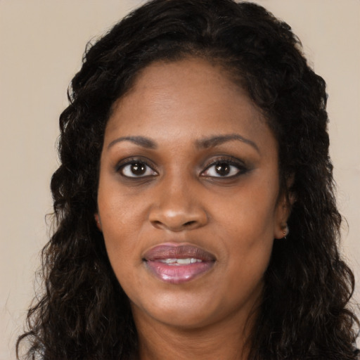 Joyful black young-adult female with long  black hair and brown eyes