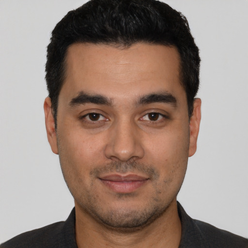 Joyful latino young-adult male with short  black hair and brown eyes