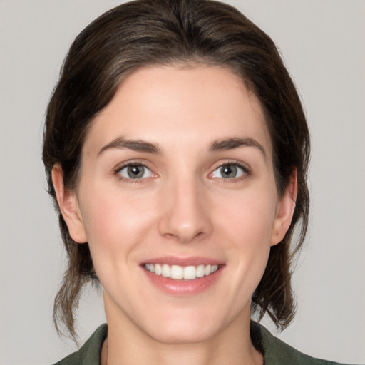 Joyful white young-adult female with medium  brown hair and green eyes