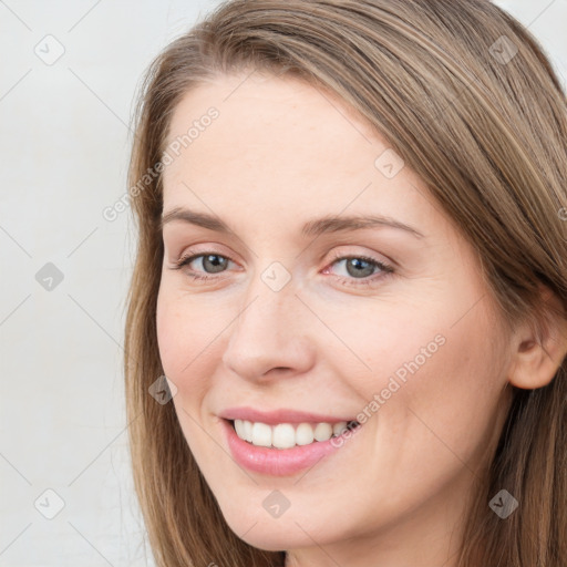 Joyful white young-adult female with long  brown hair and grey eyes