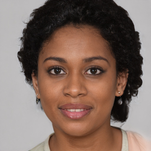 Joyful black young-adult female with medium  brown hair and brown eyes