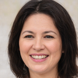 Joyful white adult female with long  brown hair and brown eyes