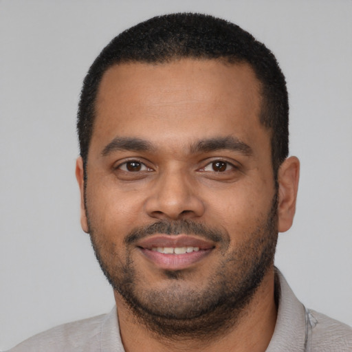 Joyful latino young-adult male with short  black hair and brown eyes