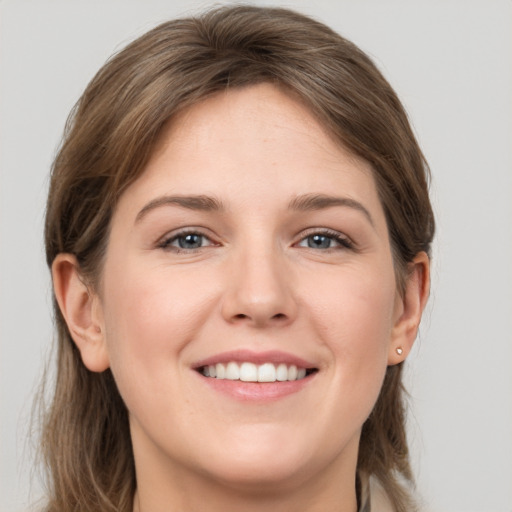 Joyful white young-adult female with medium  brown hair and grey eyes