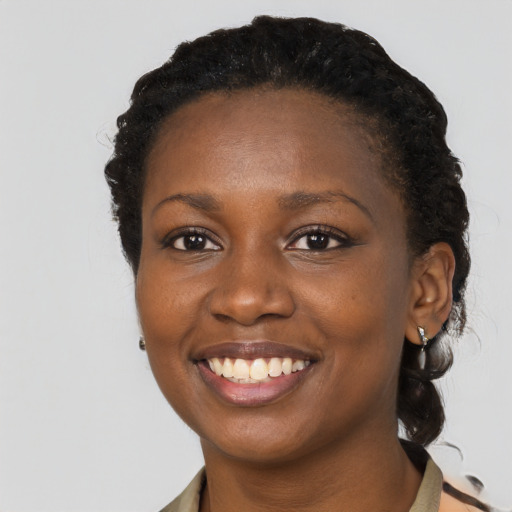 Joyful black young-adult female with short  brown hair and brown eyes