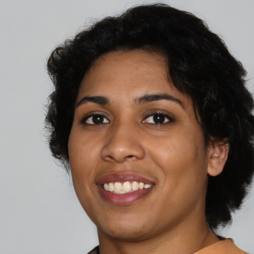 Joyful latino young-adult female with short  black hair and brown eyes