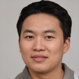 Joyful asian young-adult male with short  black hair and brown eyes