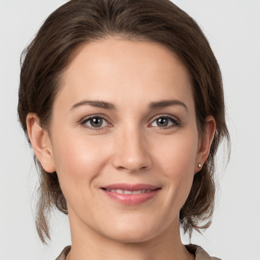 Joyful white young-adult female with medium  brown hair and grey eyes