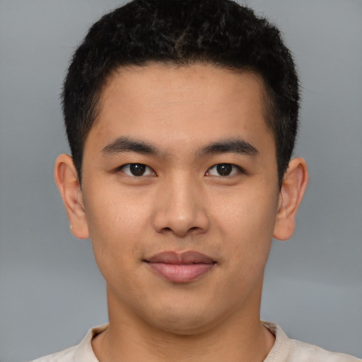 Joyful latino young-adult male with short  brown hair and brown eyes